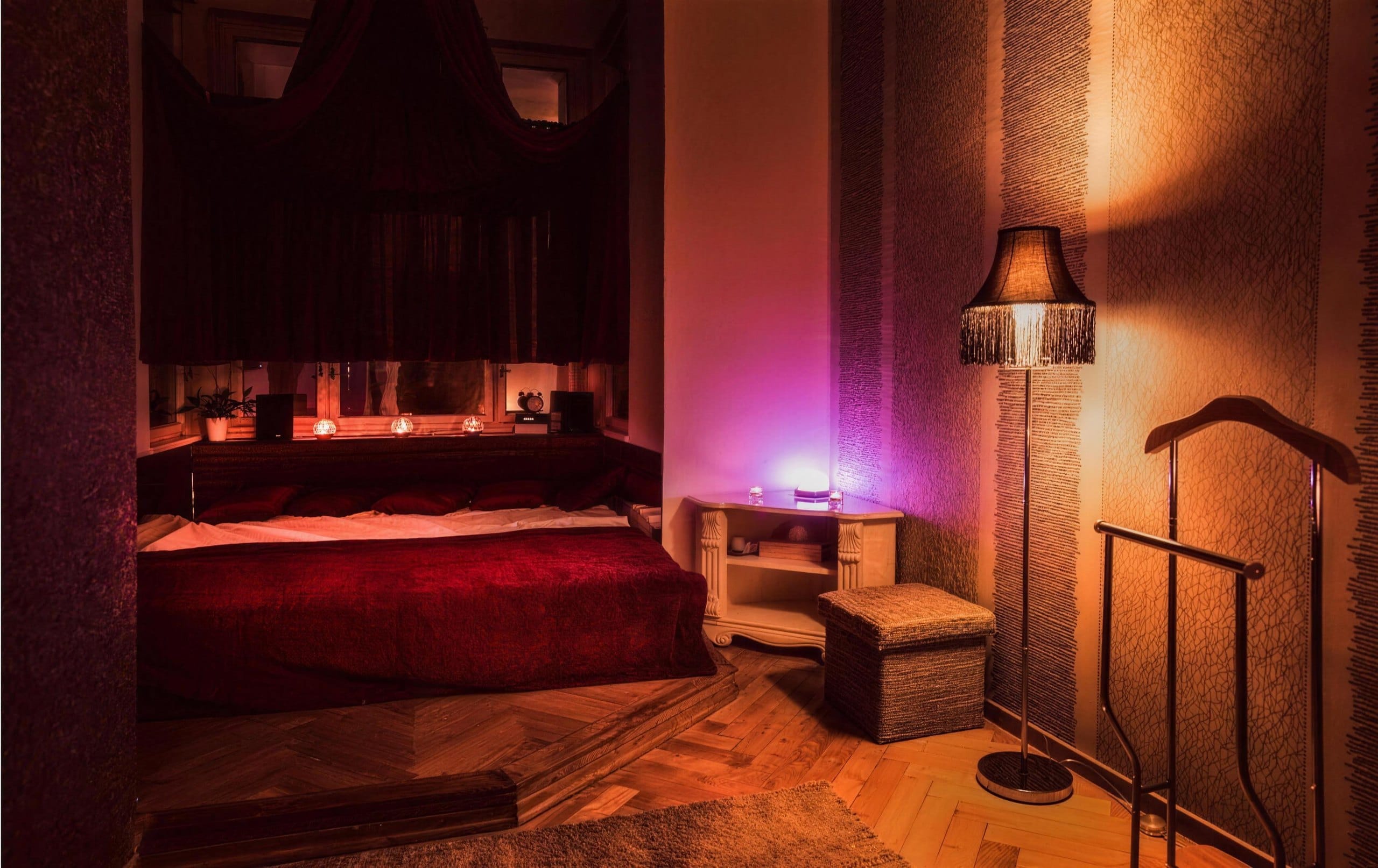 Massage room with red bedding and candlelight at Imperial salon in Prague